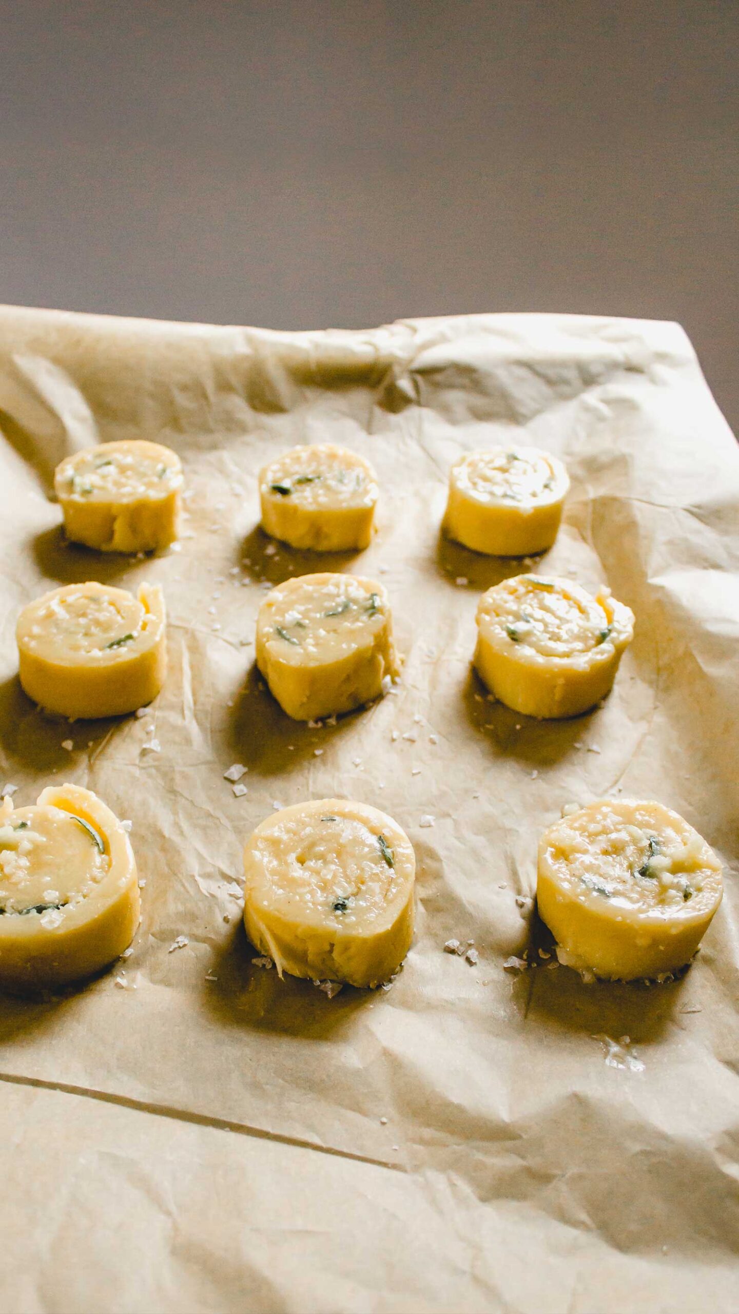 Parmesan Sage Pinwheels on a baking sheet covered with parchment paper waiting to go in the oven.