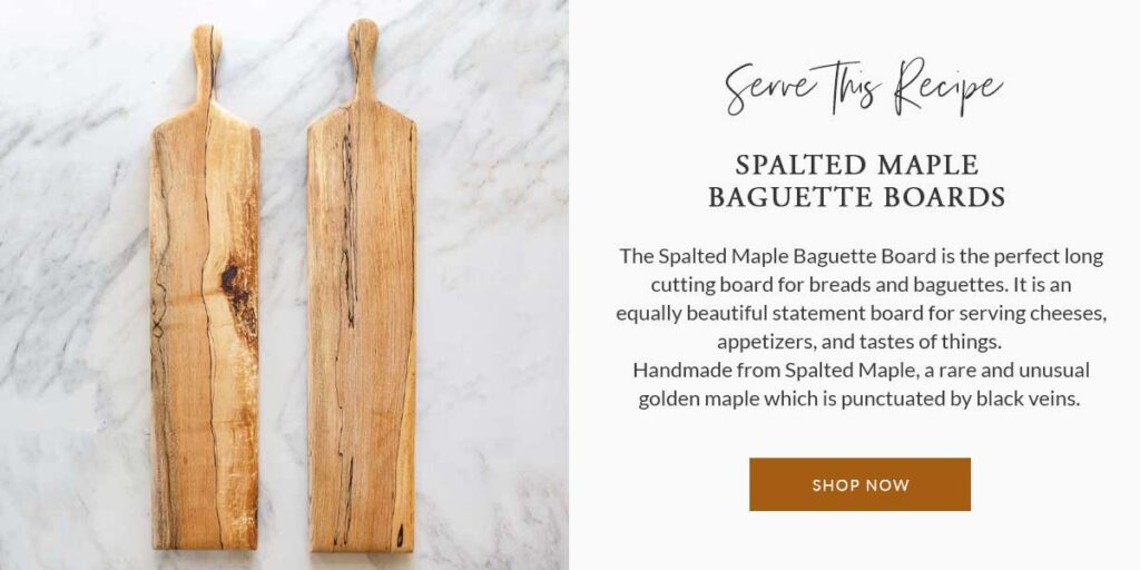 An ad for Spalted Maple Baguette Boards which are shown serving these Jammy Blue Cheese & Almond Endive Appetizer Bites and are available in my store.