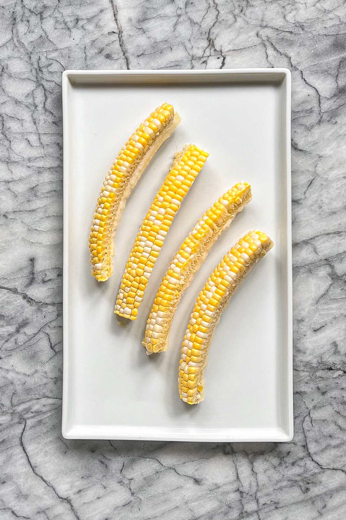 An ear of corn cut into 4 corn ribs