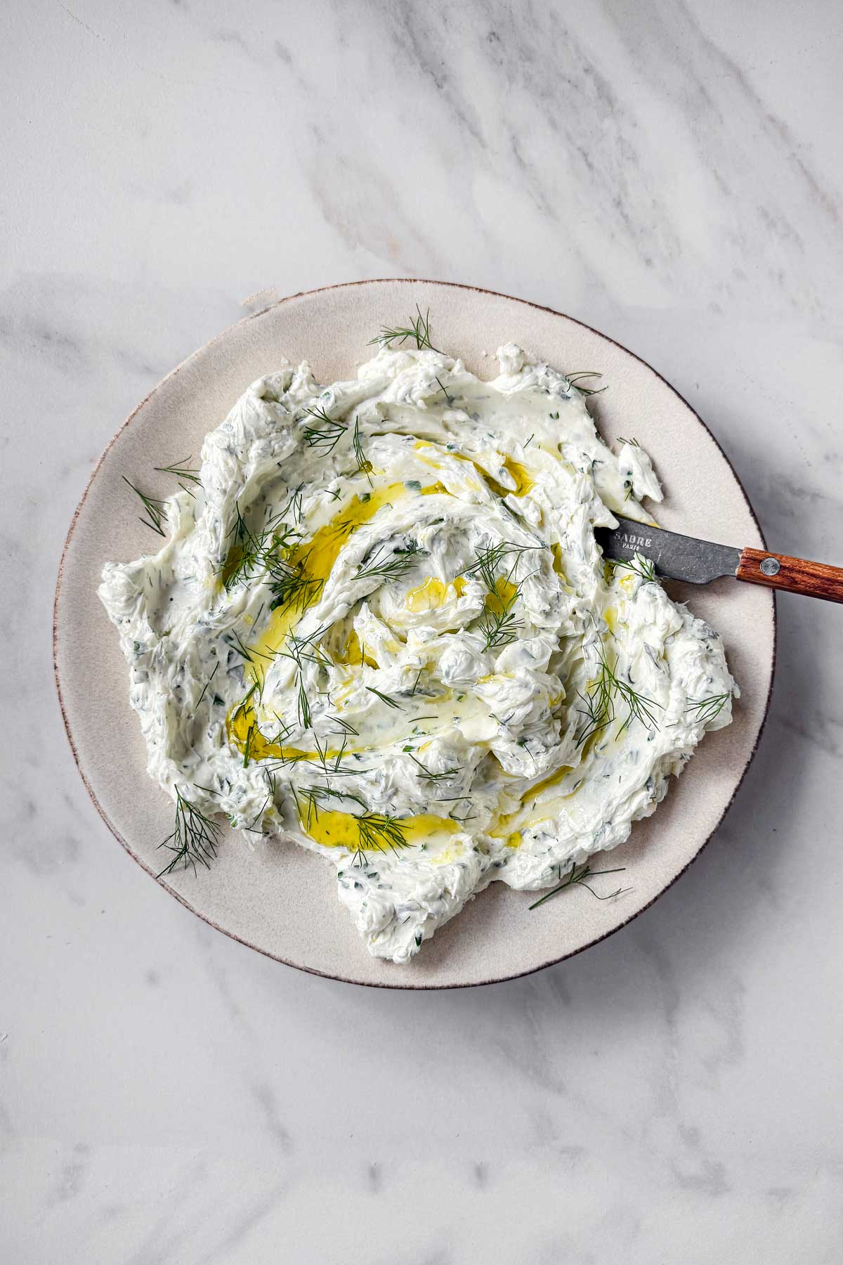 Freshly handmade Garlic Herb Cheese Dip in a pottery bowl, drizzled with olive oil