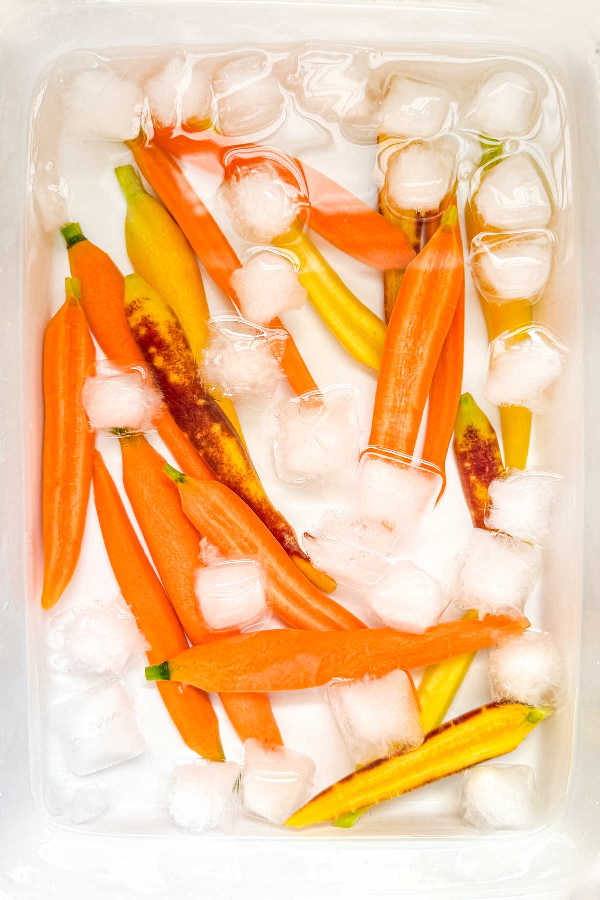 Blanching carrots in an ice bath to keep them vibrant for a crudite platter