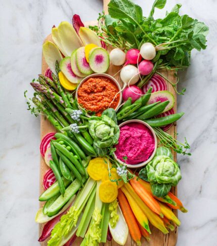Spring vegetable crudite platter with asparagus, radishes, snap peas, and dips