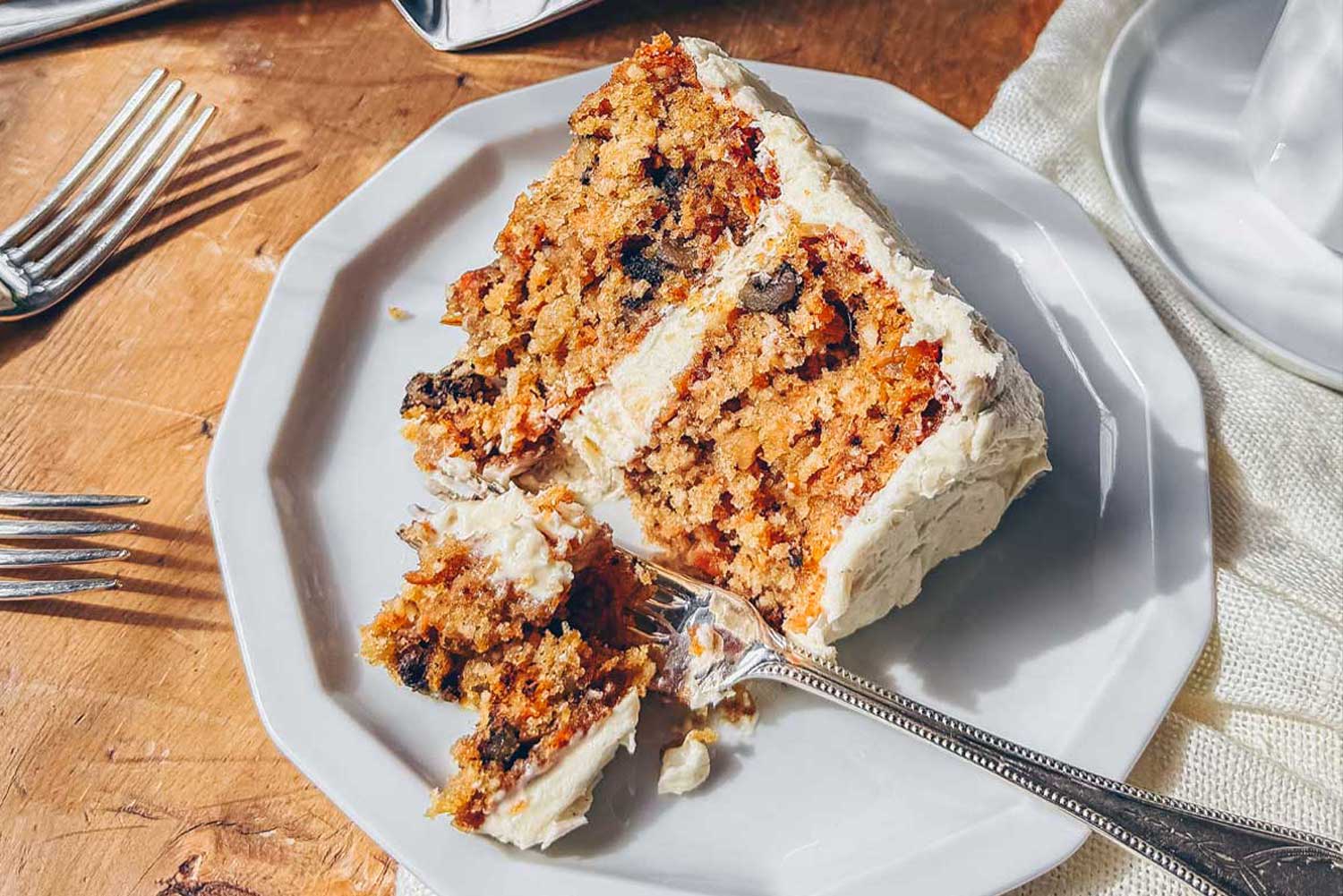 A slice of carrot cake with brown butter cream cheese frosting.